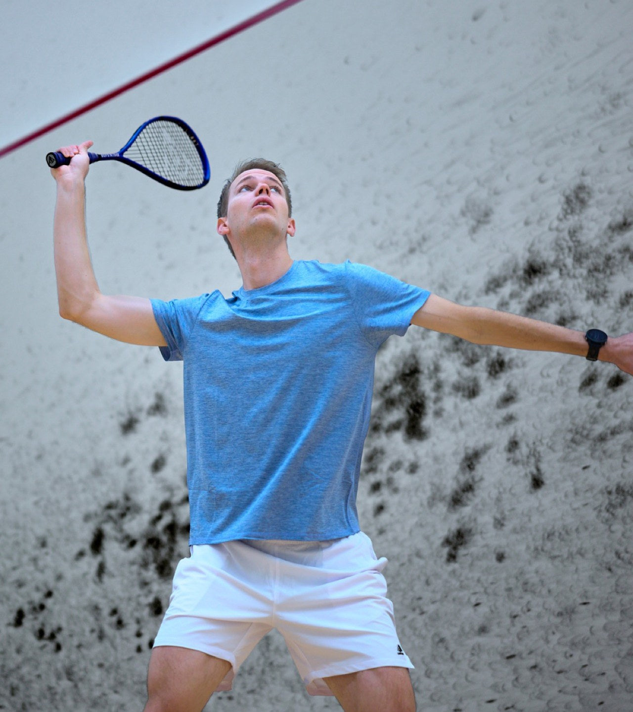 Man playing squash, mid-swing